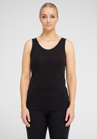 Sort ærmeløs tanktop med ribbet tekstur og rund halsudskæring. Pasformen er tætsiddende og sat sammen med matchende sorte leggings.