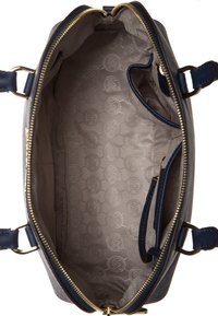 Interno di borsa blu scuro con una fodera liscia di colore chiaro e un motivo circolare. Include tasche e una chiusura con zip.