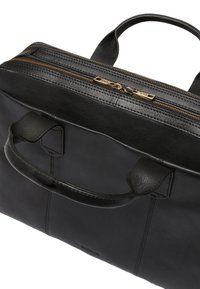 Svart läderväska med en strukturerad design, dubbla handtag högst upp och guldiga blixtlåsdetaljer; har en slät yta med synliga sömmar.