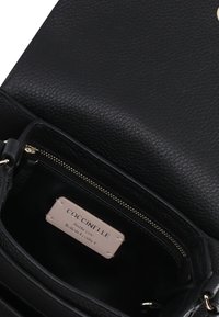 Borsa a tracolla in pelle nera con texture marmorizzata, tasca interna con zip e etichetta con la scritta "Coccinelle Vera Pelle Italiana." Chiusura sicura.