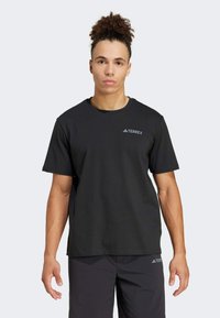 Black short-sleeve t-shirt made of cotton, featuring a round neck and a small white logo "TERREX" on the left chest area.