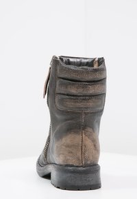 Černá kožená kotníková obuv s hnědými akcenty, texturovaný povrch, boční zip a polstrovaný podpatek pro pohodlí. Pevná gumová podrážka.