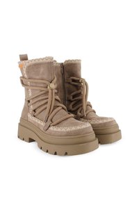 Botas de ante marrón con detalles de cordones texturizados, suelas gruesas elevadas y cremalleras en los laterales. Con bordes cosidos y una pestaña en bucle para tirar.