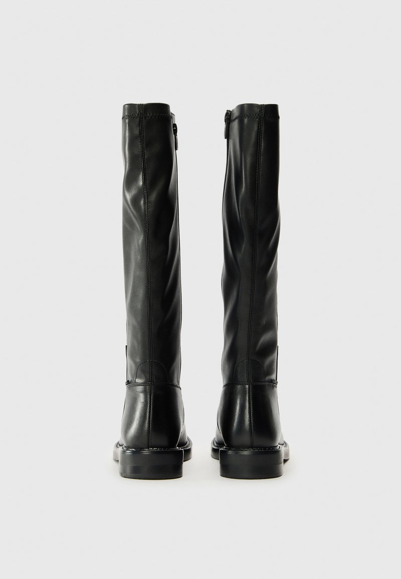Czarne skórzane kozaki do kolan o gładkiej fakturze, z suwakiem z boku i zaokrąglonym czubkiem. Solidna podeszwa z lekkim obcasem.