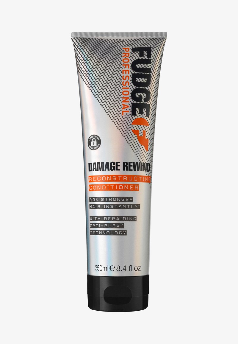 Zilveren knijptube met zwarte dop, etiket "Fudge Professional Damage Rewind" in oranje en zwart, met stippenpatroon en productdetails. 250ml.
