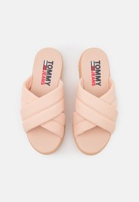 Sandali scivolati in tessuto rosa con cinturini incrociati e suola imbottita. Presentano il logo "TOMMY JEANS" stampato sulla soletta.