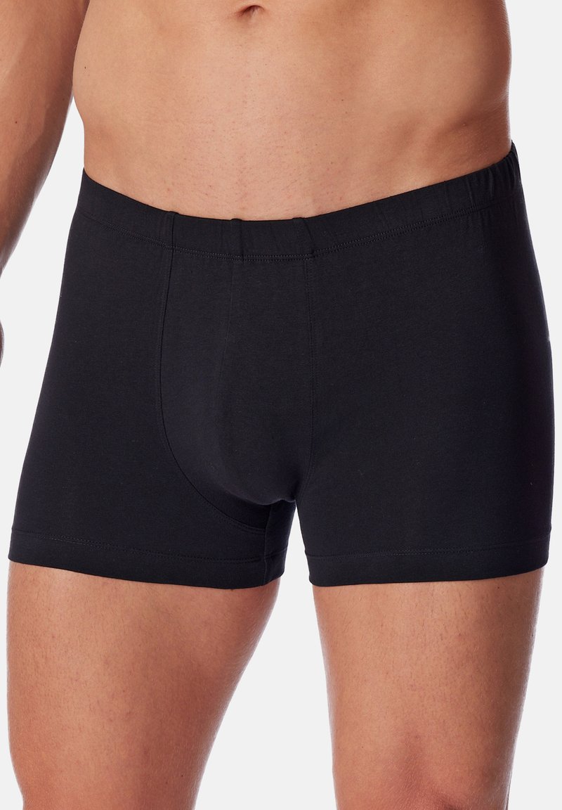 Boxers en coton noir avec une taille sans couture et une coupe ajustée. Le tissu est doux et lisse, avec un design simple et uni.