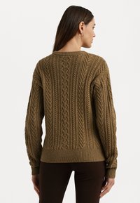 Καφέ πλεκτή ζακέτα με υφή καμπίνας, ριμπ τελείωμα και μανσέτες, και στρογγυλή λαιμόκοψη. Ιδανική για στρώσεις πάνω από βασικά ρούχα.