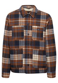 Flannel shirt in brown and navy plaid pattern, featuring a soft texture, two front pockets, and a button-down design.