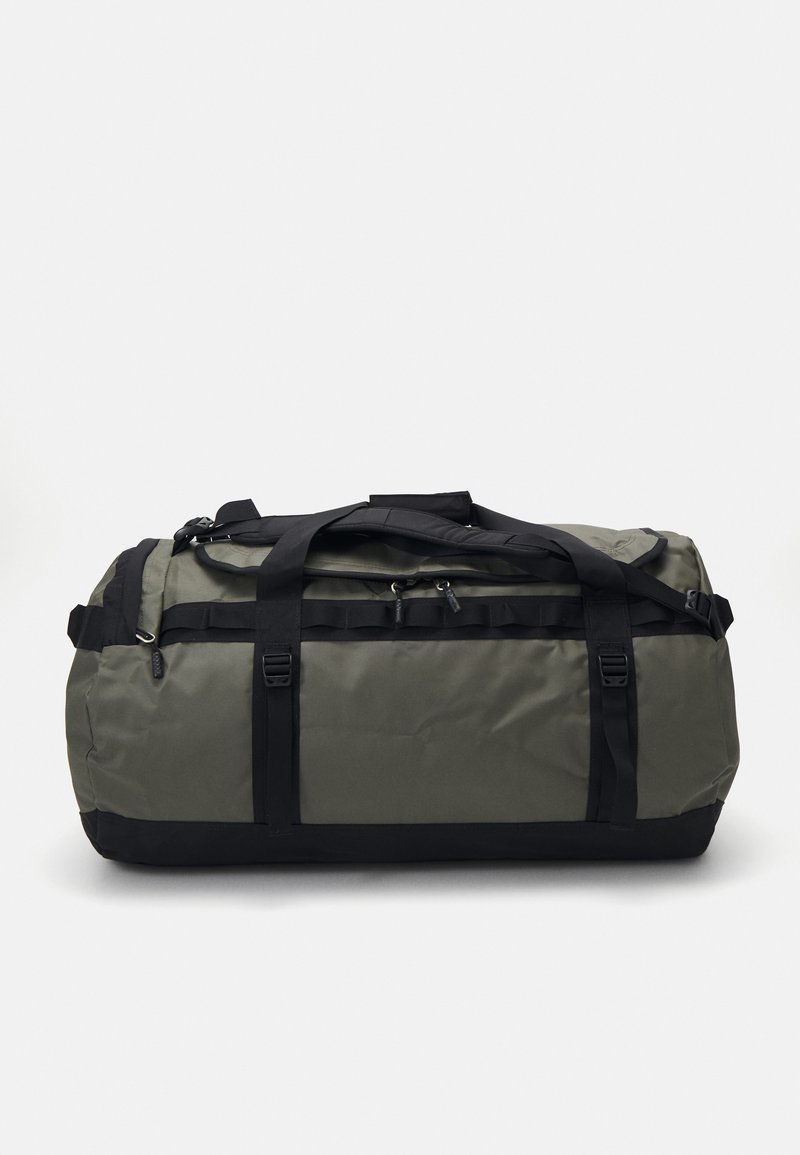Borsa duffle in nylon verde oliva con dettagli neri. Presenta manici doppi, spallacci regolabili e chiusura superiore con zip.