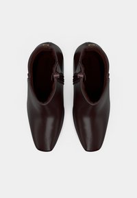 Pair of dark brown leather ankle boots with square toes and side zippers, shown from above on a white background.