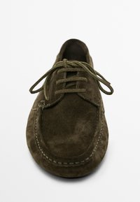 Scarpa in suede marrone con lacci, punta rotonda, cuciture visibili e superficie strutturata. I lacci sono dello stesso marrone, fissati secondo uno schema standard.
