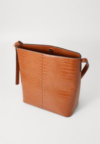 Tote torba od smeđe croko-embossed umjetne kože s jednom ručkom, otvorenim vrhom i unutarnjim oblogom vidljivim s blago savijenog ruba.