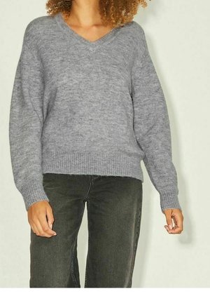 Gray, knitted sweater with a V-neckline and loose fit. Features ribbed cuffs and hem, long sleeves, and soft texture. Paired with dark jeans.