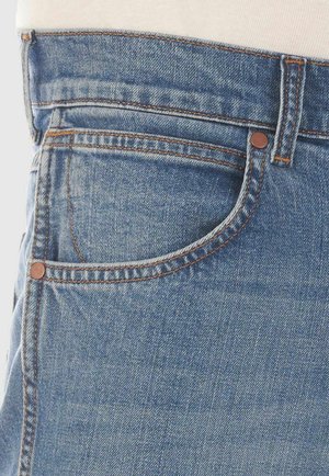 Jeans in denim azzurro chiaro con un classico design a cinque tasche, rivetti in rame e cuciture arancioni a contrasto sui bordi.