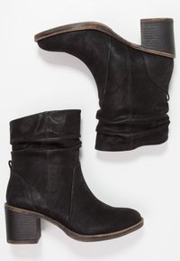 Botas negras hasta el tobillo hechas de cuero texturizado, con un diseño arrugado, punta redondeada y un tacón en bloque con acentos de apariencia madera.