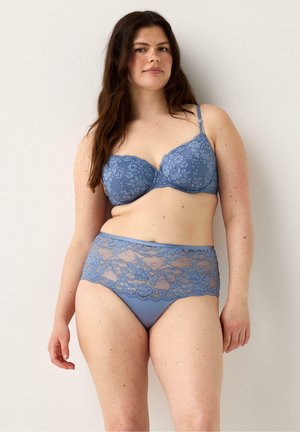 Reggiseno blu in pizzo e culotte a vita alta con motivi floreali, caratterizzati da una base in tessuto liscio e dettagli in pizzo trasparente attorno all'elastico in vita.