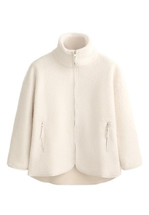 Veste en polaire crème avec col haut, fermeture éclair intégrale, deux poches latérales zippées et ourlet incurvé. Texture douce et design léger.