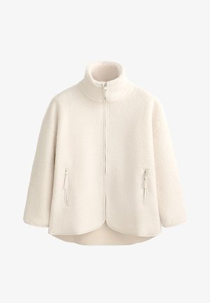 Creme fleecejakke med høj krave, fuld lynlås, to lynlåslommer på siden og en buet kant. Blød struktur og letvægtsdesign.