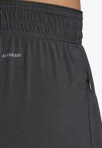 Schwarze Sportshorts aus leichtem Stoff mit einem elastischen Bund. Verfügt über eine seitliche Reißverschlusstasche und ein kleines Logo am Bund.
