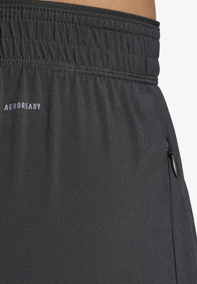 Pantalones cortos deportivos negros hechos de un tejido ligero con una cintura elástica. Cuenta con un bolsillo lateral con cremallera y un pequeño logo en la cintura.