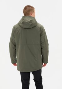 Giacca impermeabile verde con cappuccio, caratterizzata da una texture liscia e una vestibilità rilassata. La vista posteriore mostra un design semplice e funzionale.
