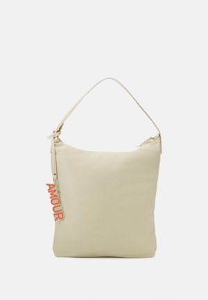 Beige schoudertas met een enkele strap en een rode "AMOUR" hanger die aan de linkerkant nabij de ritssluiting hangt.