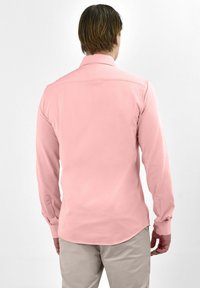 Langsleeve shirt in zacht roze stof met een button-down kraag en manchetten met één knoop, met een gebogen zoom en een gladde textuur.