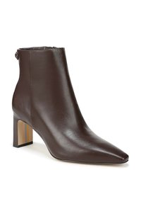 Bottine en cuir marron avec un bout pointu, un talon bloc avec des rayures horizontales et une fermeture éclair sur le côté pour un enfilage facile. Texture lisse.