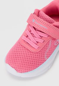 Roosa laste vabaajajalats võrgust pealiskihiga, roosad paelad, takjakinnitus märgiga "Champion" ja valge tallaga, millel on helesinine ääris.