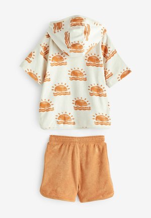 Hooded Strandüberwurf aus cremefarbenem Fleece mit Muster aus orangefarbenen Sonnen und Burgern, kombiniert mit passenden Handtuchshorts in einheitlichem Orange.