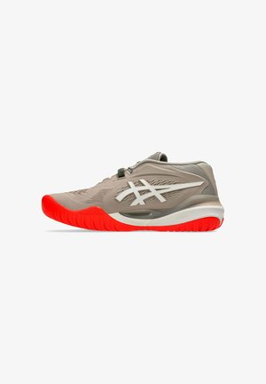 Hellbrauner Sportschuh mit weißem Logo und leuchtend roter Sohle, für den sportlichen Gebrauch entworfen, seitlich auf weißem Hintergrund dargestellt.