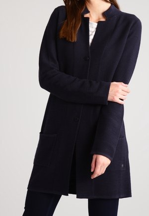 Marinefarbener langer Mantel aus strukturiertem Stoff, mit Rundhalsausschnitt, Knopfverschluss und zwei seitlichen Taschen. Einfaches Design mit taillierter Passform.