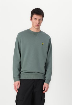 Groene katoenen sweatshirt met een ronde hals, ribgebreide manchetten en zoom. Beschikt over een klein geel vogellogo op de linkerborst. Effen structuur.