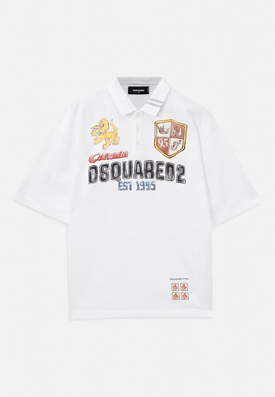 Fehér póló, hímzett grafikákkal, többek között oroszlán- és pajzs mintával. Rövid ujjú, gombos gallérral, laza szabású.