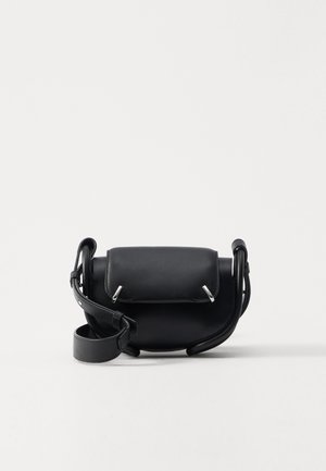 Zwarte leren crossbodytas met een ronde vorm, voorzien van een klep sluiting, zilverkleurige hardwareaccenten en een afneembare schouderriem.