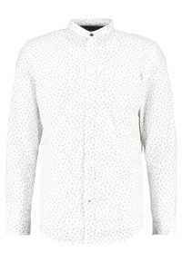 Skjorta med långa ärmar i vit bomull med knapp-down krage, prydd med ett subtilt mönster av små svarta prickar och en bröstficka.