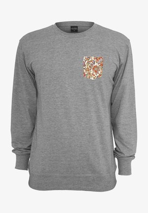 Szürke, hosszú ujjú póló, puha anyagból készült, mintás zsebbel, amely piros, kék és sárga virágmintákat tartalmaz.