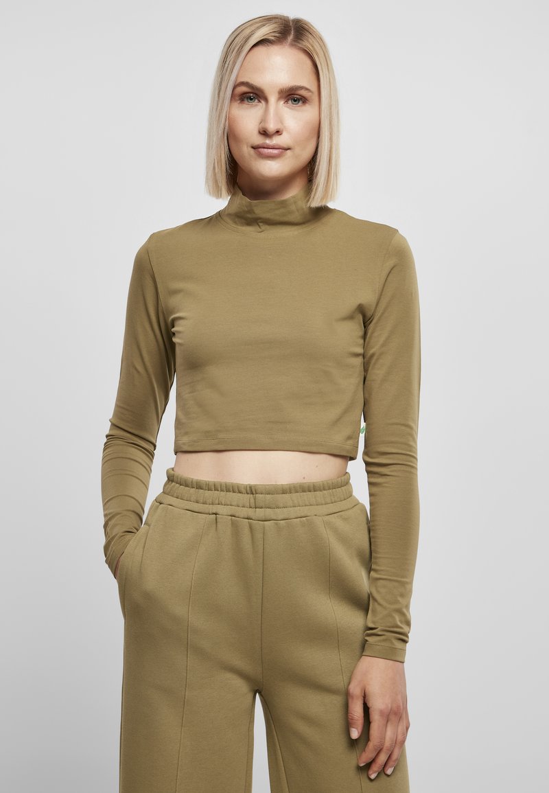 Olivenfarget langermet crop top med høy hals, tettsittende design, kombinert med matchende løse olivenbukser; glatt stofftekstur.