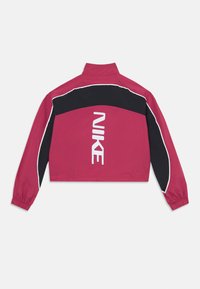 Kratka jakna v magentni in črni barvi z belimi obrobami, visokim ovratnikom in velikim belim logotipom "NIKE" na hrbtu. Ima elastične manšete.