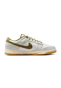 Lavtopet sneaker med hvid tekstureret overdel, olivengrøn Nike swoosh, matchende snørebånd, beige mellemsål og gummi ydersål.