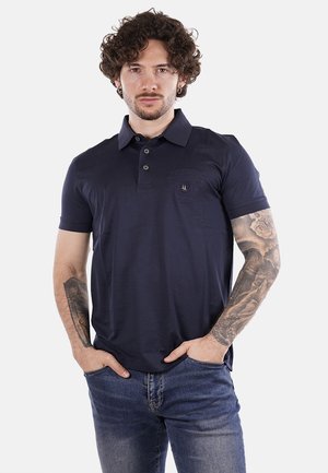 Polo shirt di un blu navy scuro con colletto, tre bottoni e un logo ricamato discreto sul petto. Tessuto morbido e maniche corte.