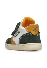 Scarpa colorata per bambini con camoscio verde, pelle bianca e accenti arancioni. Presenta una fascia in velcro e un interno imbottito. Punta arrotondata e suola testurizzata.