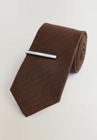 Brązowy krawat o teksturze w jodełkę, z elegancką srebrną klamrą do krawata. Krawat jest zwinięty, co uwydatnia jego tkaninę i detale wzornicze.