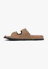 Brown fur slide sandal with a contoured footbed, open toe, and black rubber sole; features a cut-out design and smooth finishing accents.