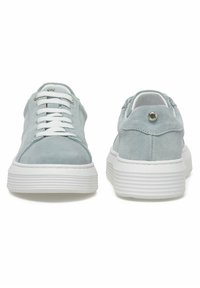 Sneaker in suede bluette con suole bianche spesse e rigate, lacci bianchi e un piccolo dettaglio in argento sul tallone.