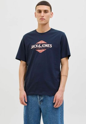 Mornarsko plavi pamučni majica s okruglim izrezom, s retro stilom loga Jack & Jones u crvenoj i bijeloj boji na prednjoj strani, opuštenog kroja, kratkih rukava.