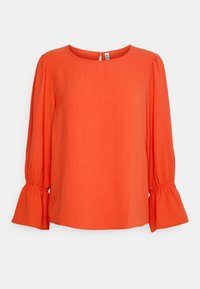 Haut orange à manches longues avec un col rond, des manches bouffantes froncées et un détail dos en forme de goutte d'eau. Confectionné dans un tissu léger et texturé.