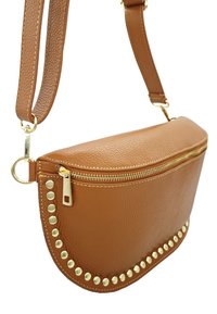 Sac à main en cuir marron avec un fond arrondi, une fermeture éclair dorée et un accent clouté le long du bord. Bandoulière réglable fixée avec du matériel doré.