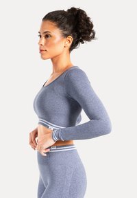 Grå langærmet cropped top med bred halsudskæring og vandret stribet bånd i bunden, lavet af et struktureret, elastisk stof.